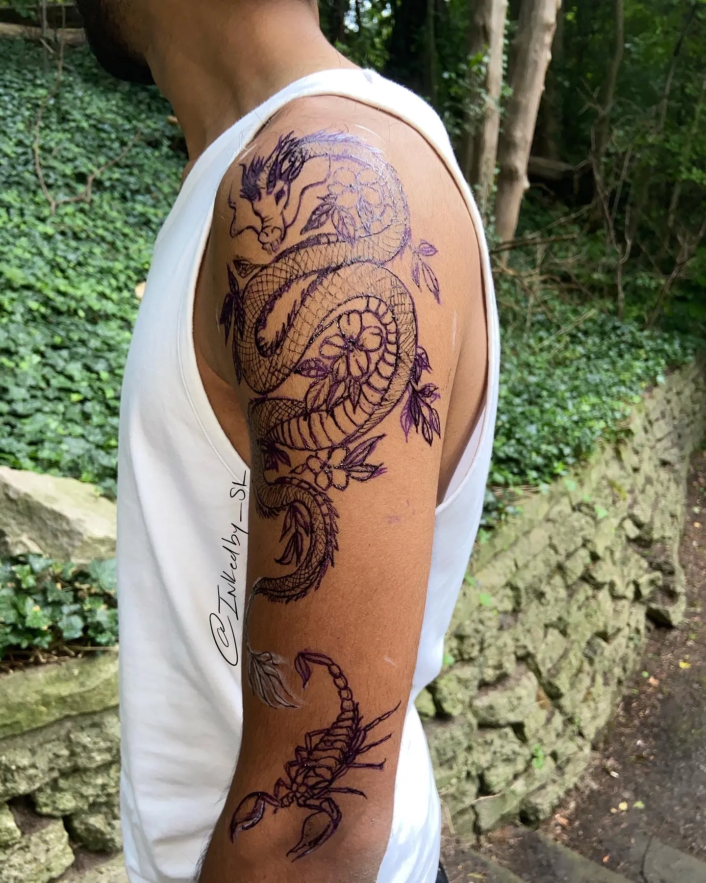 A client showing off the tattoos they received from Inked by SL.