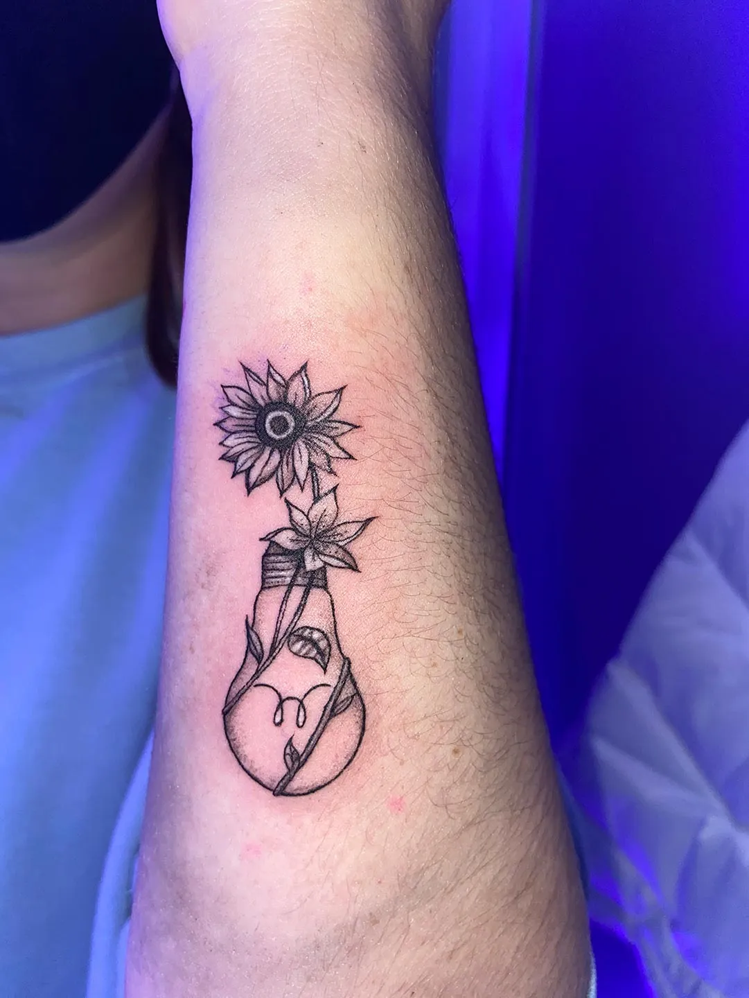 A client showing off the tattoos they received from Inked by SL.