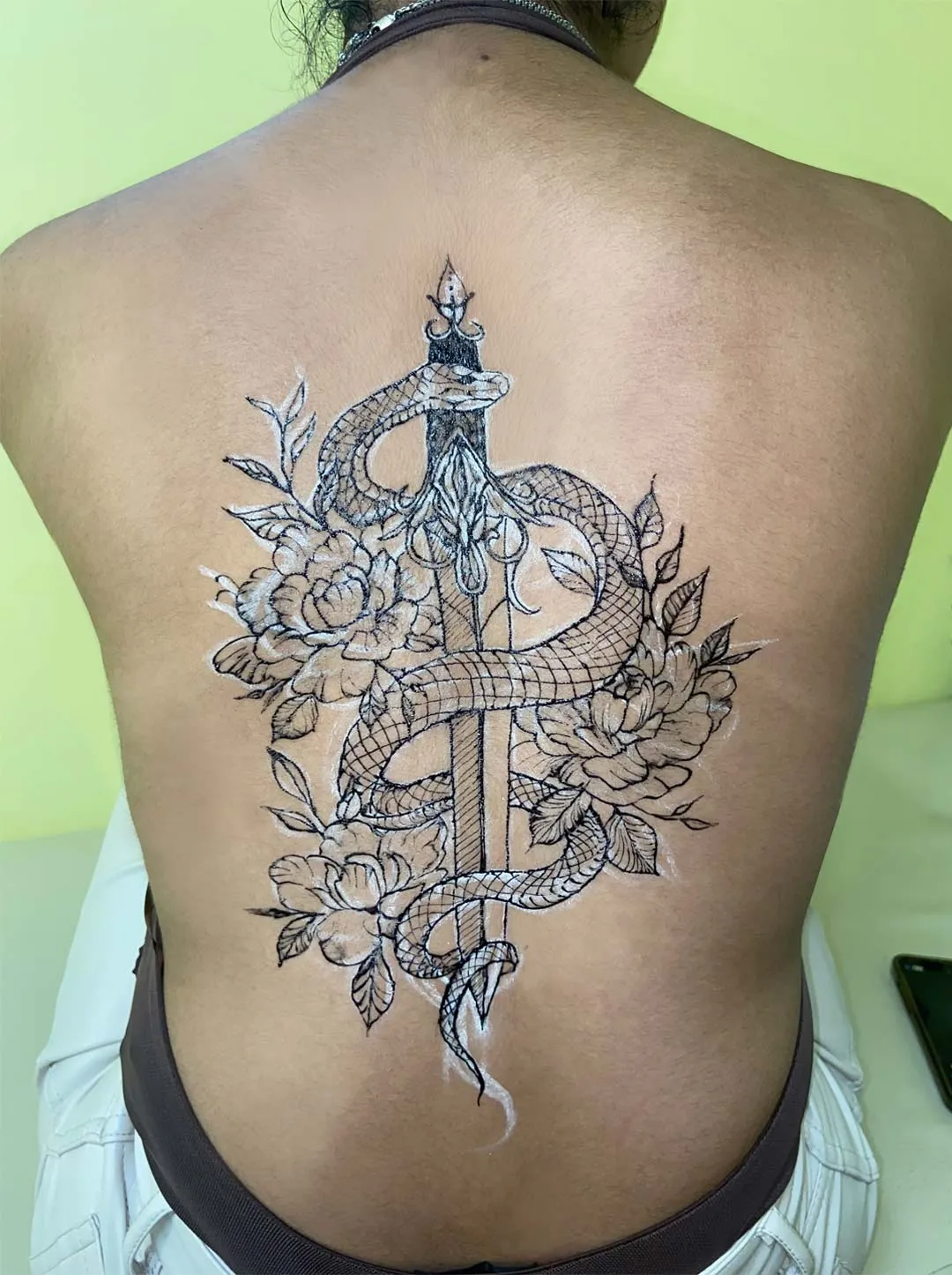 A client showing off the tattoos they received from Inked by SL.