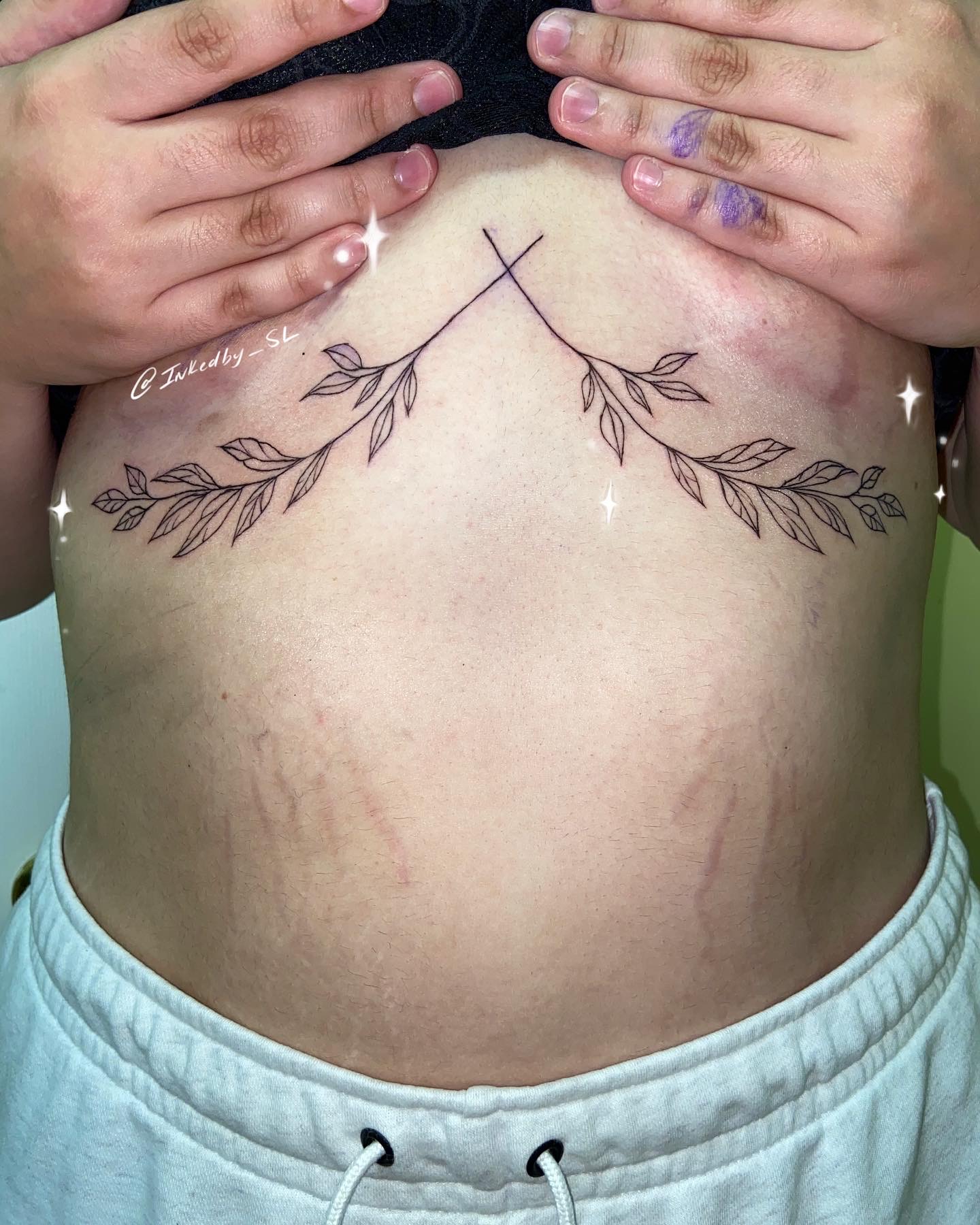 A client showing off the tattoos they received from Inked by SL.