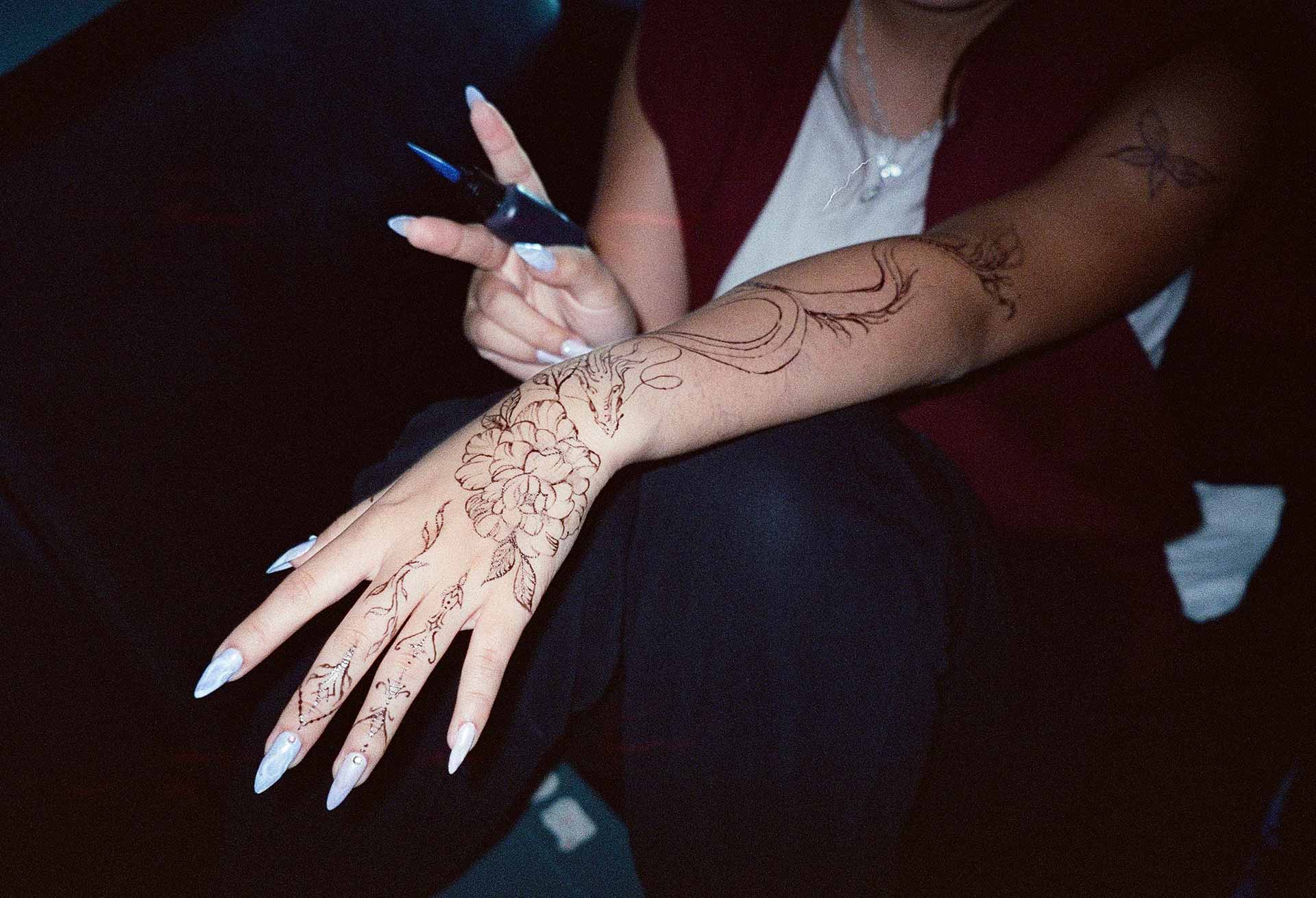 A client showing off the tattoos they received from Inked by SL.