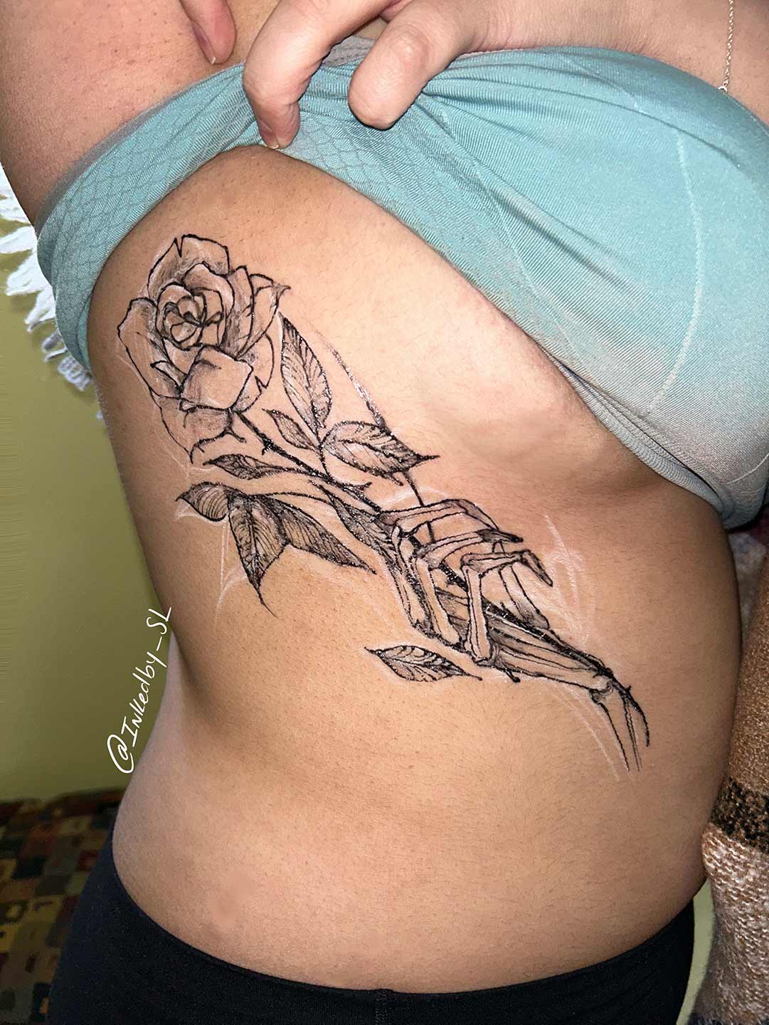 A client showing off the tattoos they received from Inked by SL.