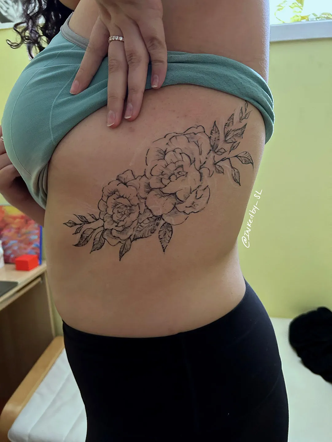 A client showing off the tattoos they received from Inked by SL.